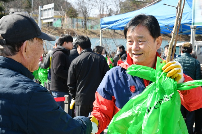 ▲ 지난해 3월 열린 나무 나눠주기 행사에서 최문순 군수가 주민들에게 묘목을 전달하고 있다. ⓒ화천군