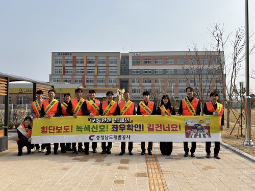 ▲ 충남개발공사 임직원들이 지난 3일 홍주초등학교 앞에서 어린이 교통안전 캠페인을 펼치고 사진을 촬영하고 있다.ⓒ충남개발공사 제공