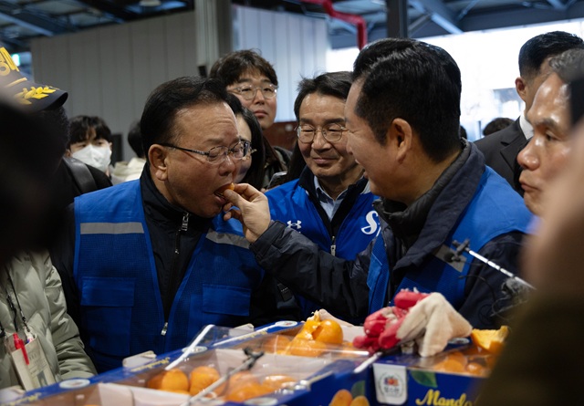 ▲ 정청래 더불어민주당 대표가 8일 오전 대구 북구 매천동 농수산물도매시장에서 민생현장 체험을 하던 중 김부겸 민주당 대구시장 후보에게 귤을 먹여주고 있다. ⓒ뉴시스