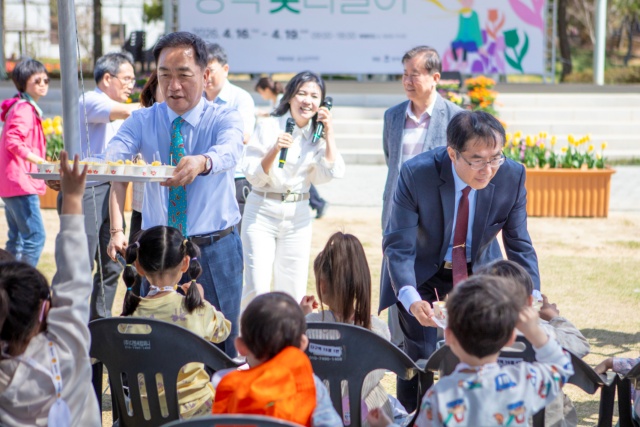 ▲ 정장선 시장과 황웨이저 대만 타이난시장이 평택꽃나들이 행사에서 어린이들에게 파인애플을 나눠주고 있다ⓒ평택시 제공