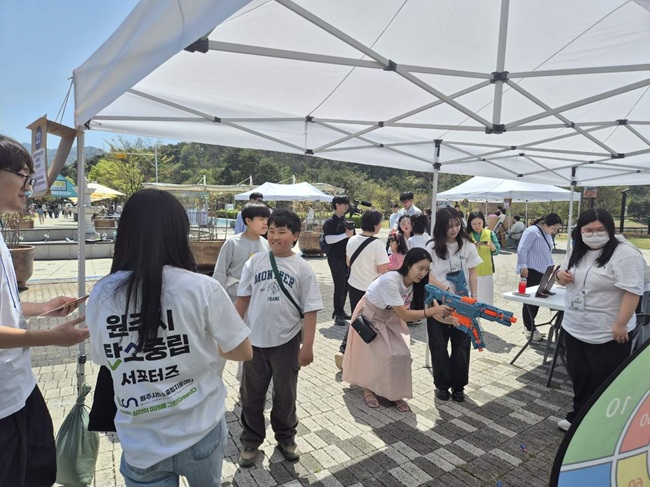 ▲ 한국보훈복지의료공단이 '지구의 날'을 맞아 18일 원주시 탄소중립 서포터즈와 손잡고 '탄소중립 캠페인'을 원주시에서 전개했다. 이날 보훈공단은 체험형 프로그램 참여자에게 보훈병원 및 보훈요양원의 폐유니폼으로 만든 '업사이클링 여행용 주머니'를 증정했다. ⓒ한국보훈복지의료공단