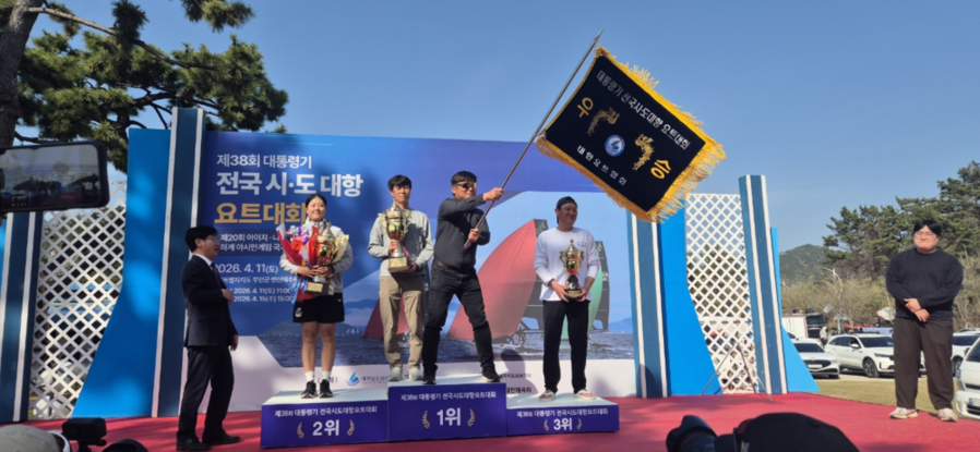 ▲ 대통령기 요트대회에서 종합우승기를 흔드는 전라남도 요트팀_(왼쪽에서 세 번째 보성비봉마리나요트 최정현 코치, 네 번째 여수고 김성현 코치)ⓒ여수시 제공