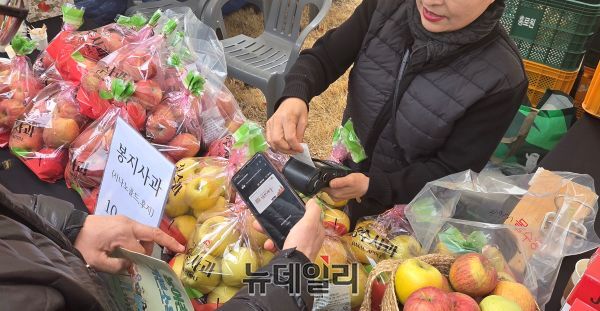 ▲ 전북 장수군의 한 군민이 '농어촌 기본소득'으로 사과를 구매하고 있는 모습. ⓒ뉴데일리