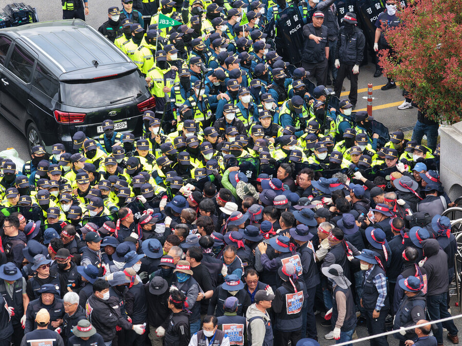 ▲ 지난 20일 경남 진주시 정촌면 BGF로지스 진주센터에서 화물연대 관계자가 센터 입구로 진입하려는 과정에서 경찰과 대치하고 있다.ⓒ연합뉴스