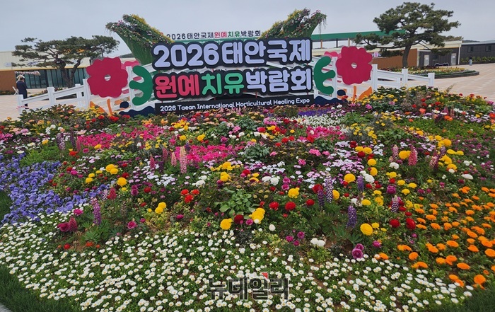 ▲ 충남 태안군 안면도 꽃지해안공원에 조성된 ‘2026 태안국제원예치유박람회’ 홍보 조형물 앞에 형형색색의 봄꽃이 만개해 관람객을 맞이하고 있다.ⓒ이길표 기자