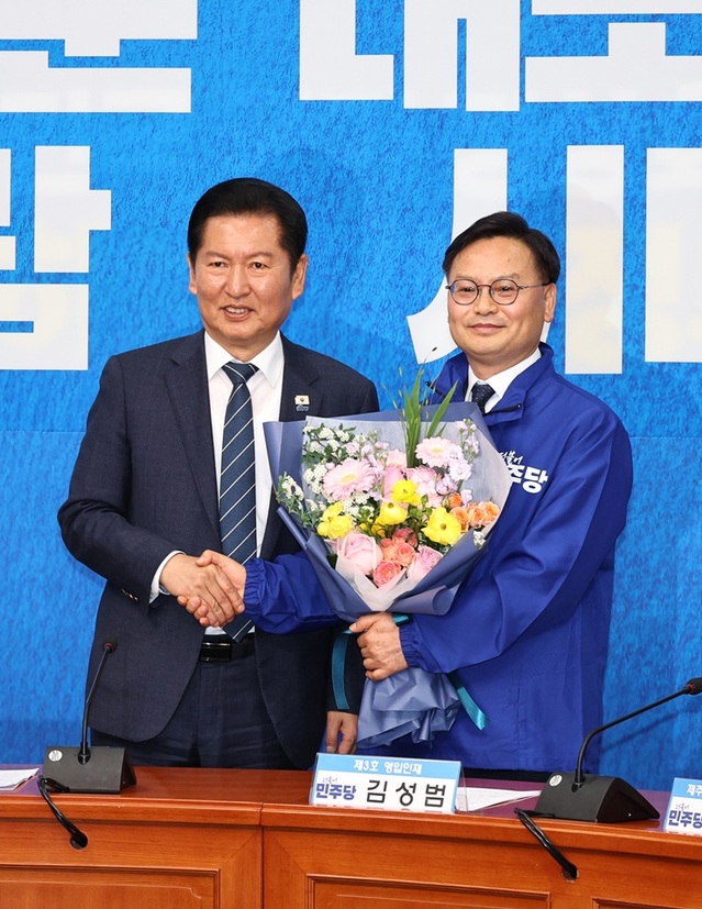 ▲ 정청래 더불어민주당 대표가 30일 국회에서 열린 3차 인재영입식에서 김성범 전 해양수산부 차관에게 당점퍼를 입혀주고 기념 촬영을 하고 있다. ⓒ뉴시스