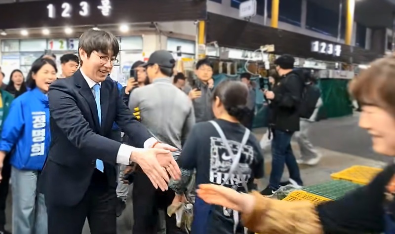 ▲ 부산 북구갑 보궐선거 출마를 공식화한 하정우 전 청와대 수석이 지난 29일 부산 구포시장 방문 도중 상인과 악수를 하려고 손을 뻗고 있다. ⓒ유튜브 '황기자TV' 캡쳐