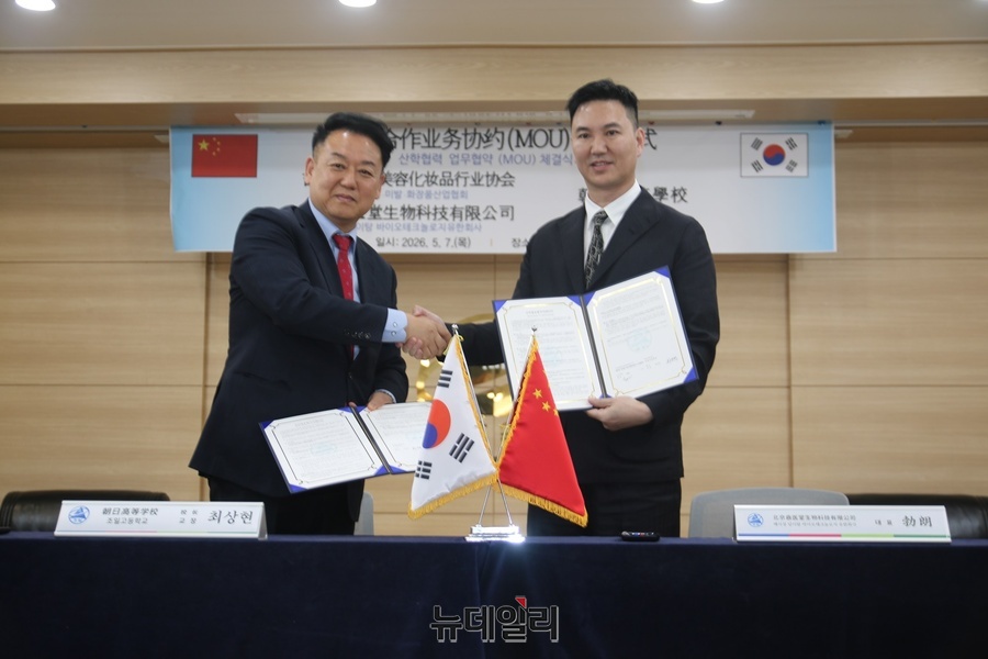 ▲ 보랑(BO, LANG) 중국 딩이탕 하이테크 뷰티 대표(오른쪽)이 최상현 교장과 협약서에 서명한 후 협약서를 교환하고 있다.ⓒ뉴데일리
