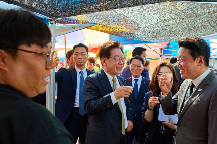 ▲ 이재명 대통령이 지난 14일 경기 성남 모란시장을 방문해 강훈식 비서실장과 시식을 하며 대화하는 모습. ⓒ청와대 제공