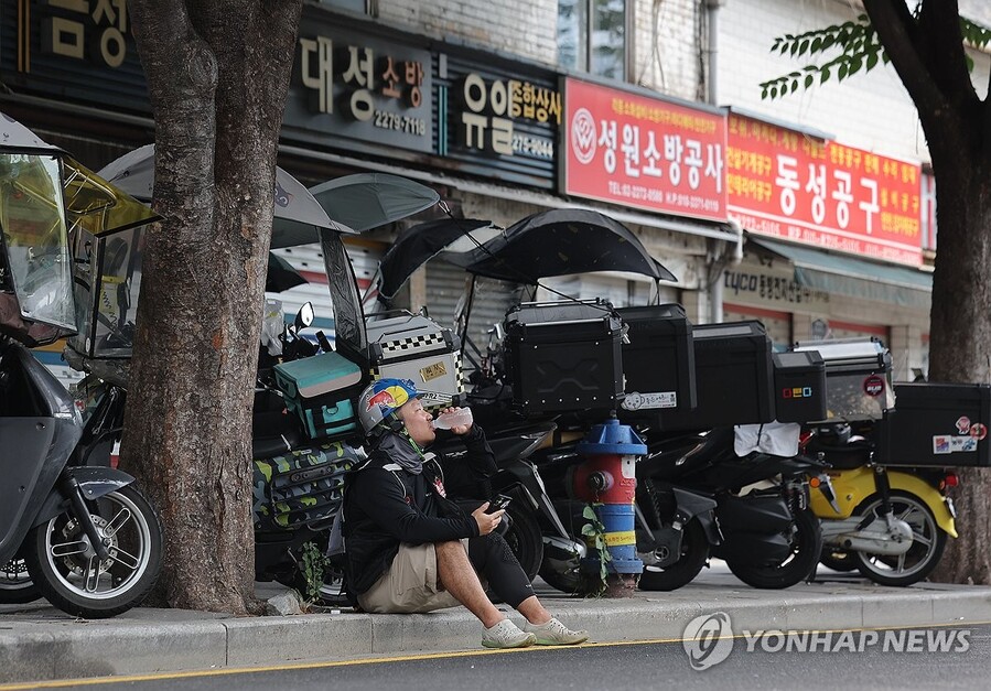 ▲ 폭염이 계속되는 30일 서울 시내에서 한 배달 노동자가 물을 마시며 더위를 식히고 있다. ⓒ연합뉴스