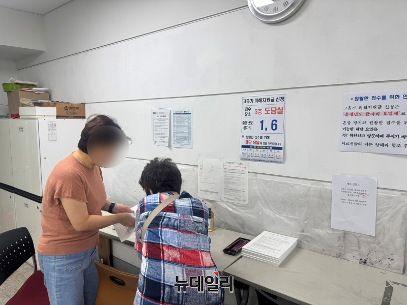 ▲ 19일 오전 서울 마포구 주민센터에서 고령층 시민이 안내원의 도움을 받으며 종이 신청서를 작성하고 있다. ⓒ임찬웅 기자