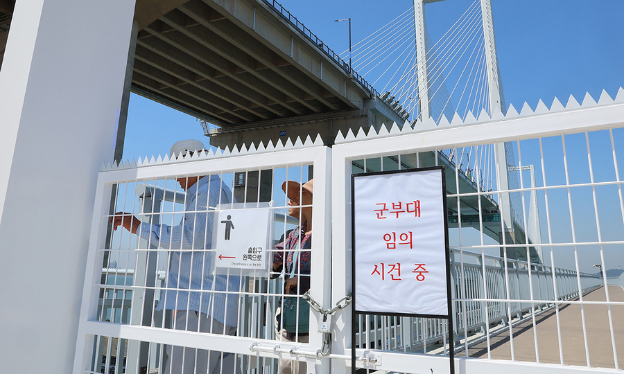 ▲ 지난 7일 개장한 인천 서구 청라하늘대교 관광시설인 해상데크 출입문이 군 당국이 설치한 쇠사슬과 자물쇠로 통제되고 있다. 이때문에 이용객들은 출입문을 피해 쪽문으로 통행하고 있다.ⓒ연합뉴스 제공