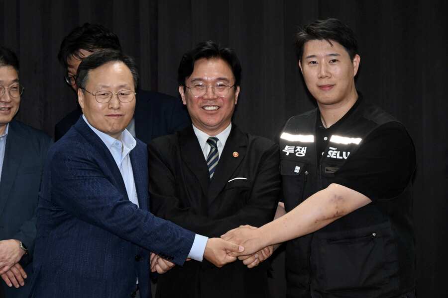 ▲ 삼성전자 노사 협상이 잠정 합의된 지난 20일 경기도 수원시 장안구 경기지방고용노동청에서 김영훈 고용노동부 장관, 최승호 삼성전자 노조 공동투쟁본부 위원장, 여명구 DS(디바이스솔루션·반도체 사업 담당) 피플팀장이 손을 맞잡은 모습. ⓒ뉴시스