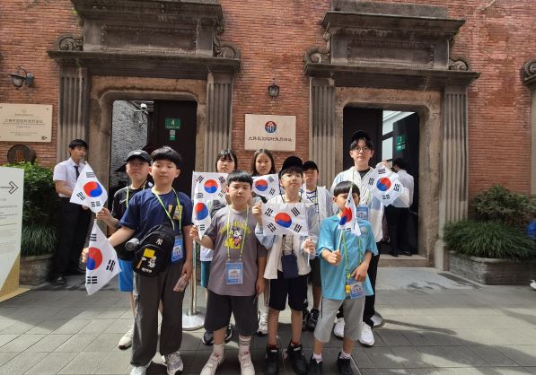 ▲ 중국 상하이 대한민국 임시정부 청사를 찾은 울릉 천부초등학교 학생들이 태극기를 들고 국권 회복을 위해 헌신한 선열들의 뜻을 기리며 기념촬영을 하고 있다.ⓒ천부초등학교 제공