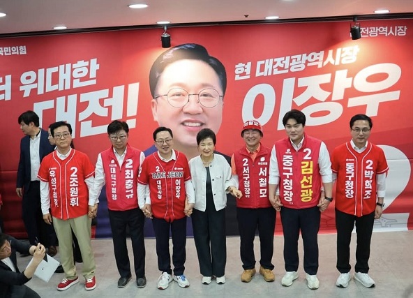 ▲ 박근혜 전 대통령이 25일 이장우 대전시장 캠프를 방문, 이 후보와 대전 5개 구청장 후보들과 손을 맞잡고 사진촬영을 하고 있다.ⓒ이장우 후보 캠프 제공.