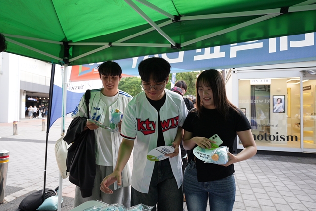 ▲ 2일 수원 kt 위즈파크에 마련된 경기대학교 부스에서 학교 관계자들이 경기대학교 마스코트 '기룡이 인형 키링'을 배부하고 있다. ⓒ경기대 제공