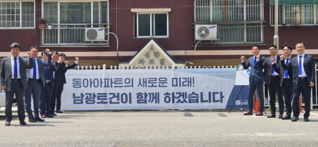 ▲ 강경민 극동건설 대표(왼쪽 첫번째)와 임직원들이 인천 용현동 동아아파트 현장에서 기념촬영을 하고 있다. ⓒ남광토건