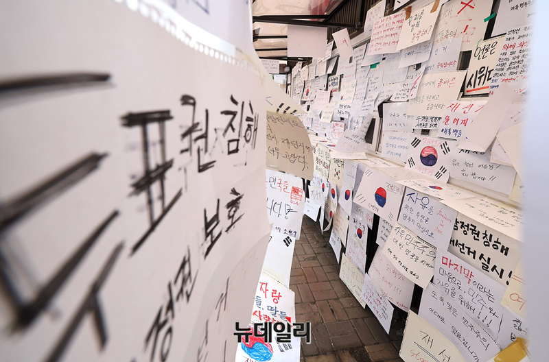 ▲ 6·3 지방선거 당시 잠실7동 제2투표소에서 발생한 투표용지 부족 사태를 계기로 시작된 잠실 개표소 앞 집회가 닷새째 이어지고 있는 지난 9일 오후 티켓박스에 시민들이 손수 적은 재선거 메시지로 가득하다. ⓒ정상윤 기자