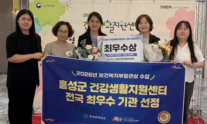 ▲ 홍성군보건소가 지난 10일 서울 피스앤파크컨벤션에서 열린 ‘2026년 건강생활지원센터 운영 성과대회’에서 농어촌형 최우수기관으로 선정돼 보건복지부장관상을 수상한 뒤 관계 공무원들과 기념촬영을 하고 있다.ⓒ홍성군