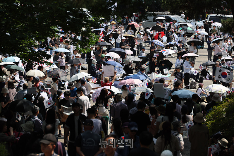 ▲ 일주일째 이어지고 있는 서울 송파구 올림픽공원 개표소 재선거 촉구현장에 11일 오후 시민들이 양산을 쓰고 '부정선거 재선거, 당일투표 수개표' 구호를 외치고 있다. 집회 현장에는 밤낮 기온차를 보완할 수 있는 온냉방버스와 단식을 촉구하는 시민이 등장하기도 했다. ⓒ 정상윤 기자