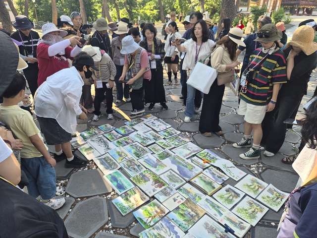 ▲ 제2회 여행드로잉 ‘보경사를 그리다’ 행사 후 참가자들이 직접 그린 그림을 한데 펼쳐 놓고 살펴보고 있다.ⓒ뉴데일리