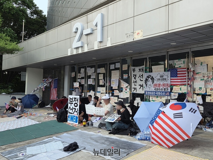 ▲ 16일 오후 서울 송파구 올림픽공원 핸드볼경기장 2-1 게이트 앞에서 시위에 참가한 시민들이 출입문을 봉쇄한 채 앉아 있다. ⓒ노유지 기자