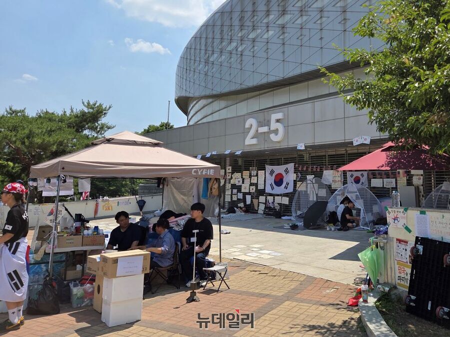 ▲ 17일 오후 서울 송파구 올림픽공원 핸드볼경기장 2-5 게이트 앞에서 자원봉사자들이 천막에 앉아 휴식을 취하고 있다. ⓒ노유지 기자
