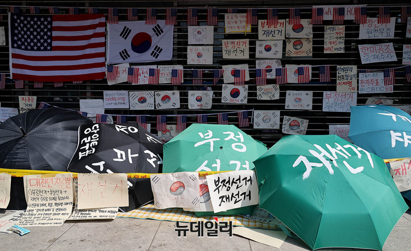 ▲ 6·3지방선거 투표용지 부족 사태로 촉발된 잠실 개표소 봉쇄 집회가 14일째를 맞은 18일 오전 서울 송파구 올림픽공원 핸드볼경기장 개표소 현장에 성조기 등이 걸려있다. ⓒ정상윤 기자