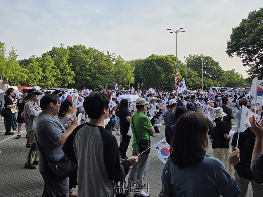 ▲ 18일 오후 서울 송파구 올림픽공원 핸드볼경기장 일대에서 집회에 참가한 시민들이 태극기를 흔들고 있다. ⓒ노유지 기자