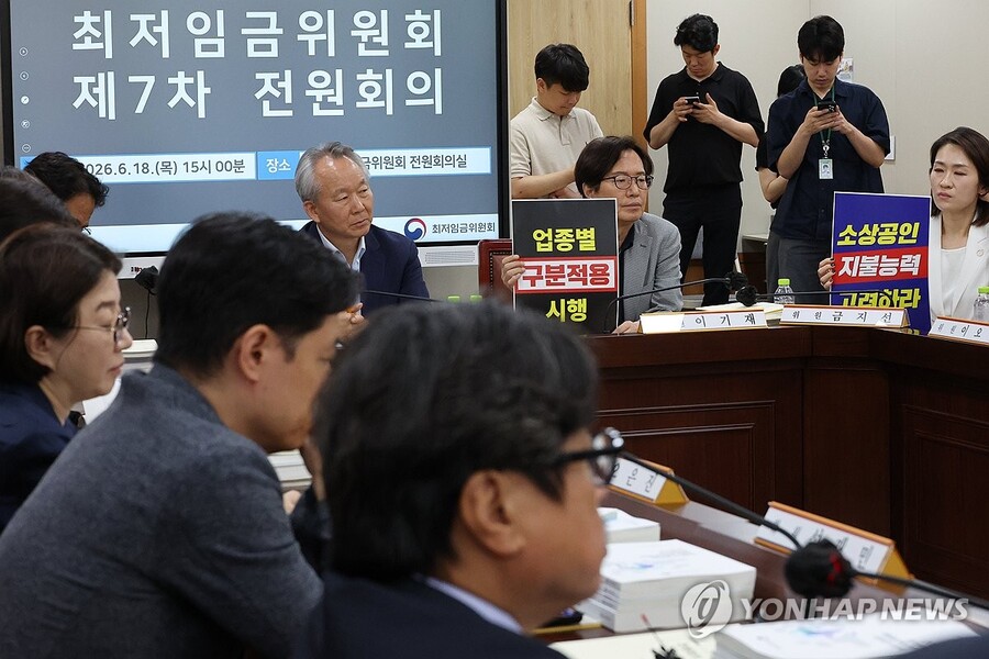 ▲ 18일 정부세종청사 최저임금위원회에서 열린 제7차 전원회의에서 사용자 위원들이 최저임금의 업종별 구분적용을 요구하는 피켓을 들고 있다. ⓒ연합뉴스