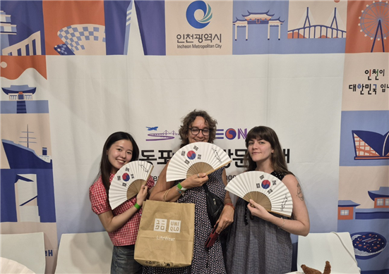 ▲ K-EXPO SPAIN 2026 행사장을 찾은 관람객들이 인천시 기념품인 태극기 부채와 함께 사진 촬영을 하고 있다. ⓒ인천시 제공