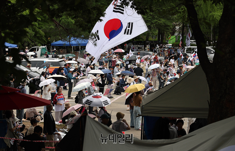 ▲ 24일 오후 서울 송파구 올림픽공원 핸드볼경기장 일대에서 집회에 참가한 시민들이 태극기를 흔들고 있다. ⓒ정상윤 기자