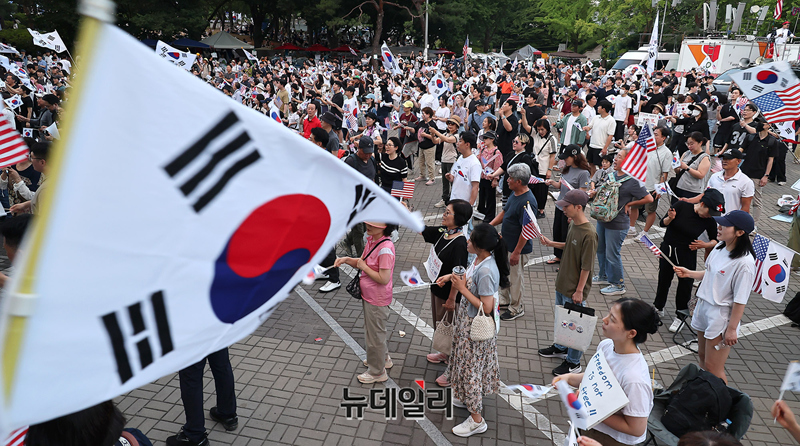 ▲ 지난 27일 오후 서울 송파구 올림픽공원 핸드볼경기장 1-3 게이트 앞에서 집회 참가자들이 태극기를 흔들고 있다. ⓒ정상윤 기자