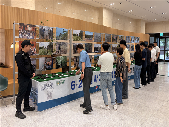 ▲ 관람객들이 지난 19일 한국예탁결제원 서울사옥 로비에서 열린 6·25 전사자 유해발굴 사진·유품 전시를 관람하고 있다. ⓒ한국예탁결제원