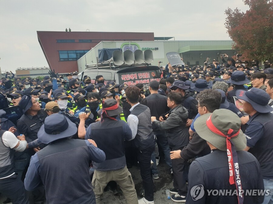 ▲ 지난 4월 20일 오후 경남 진주시 정촌면 BGF로지스 진주센터에서 화물연대 관계자가 센터 입구로 진입하려는 과정에서 경찰과 대치하고 있다. ⓒ연합뉴스