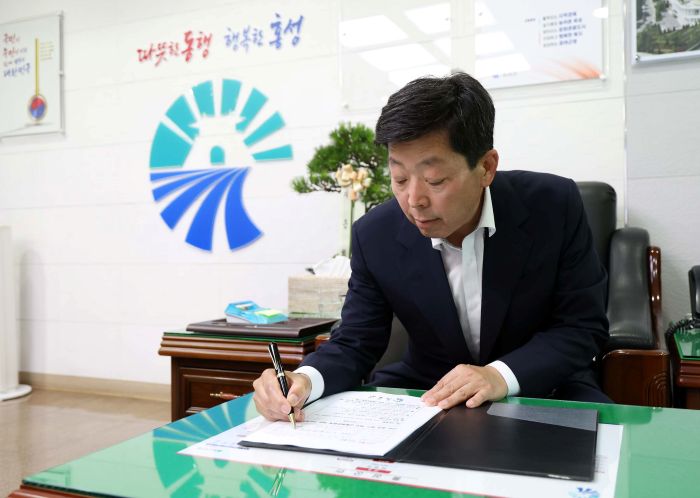 ▲ 박정주 홍성군수가 1일 군수 집무실에서 취임 후 첫 결재로 '대중교통 체계 전면 개편' 추진안을 결재하고 있다. 이번 1호 결재에는 75세 이상 어르신 대상 효도택시 도입, 학생 전용 통학버스 운행, 농어촌버스 노선 개편 등 군민 중심의 교통복지 정책이 담겼다.ⓒ홍성군