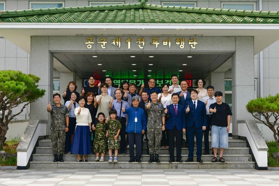 ▲ 병역명문가 가족들이 제1전투비행단 단본부 현관에서 부대 안보견학 기념사진을 촬영하는 모습ⓒ공군 제1전투비행단 제공