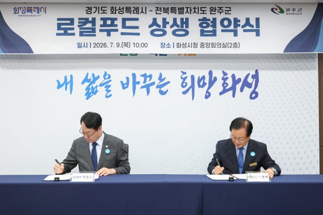 ▲ 정명근 시장과 유희태 군수가 로컬푸드 활성화 및 도농 상생 협력을 위한 업무협약서에 서명하고 있다ⓒ화성시 제공