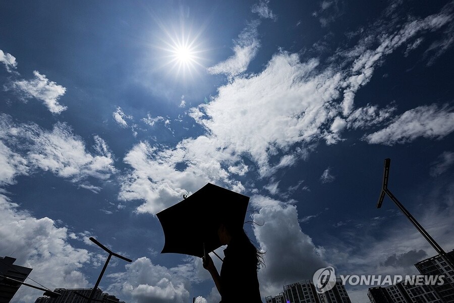▲ 대구에 폭염주의보가 발효 중인 10일 동대구역 광장에서 한 시민이 양산을 쓰고 이동하고 있다. ⓒ연합뉴스