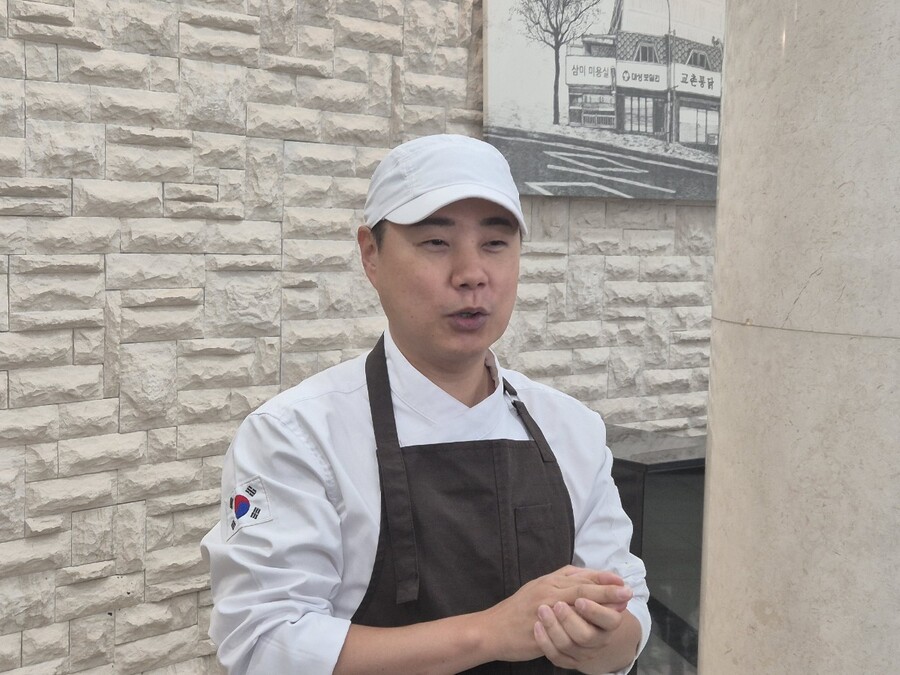 ▲ 도민수 교촌1991스쿨 팀장이 협동 조리 로봇에 대해 설명하고 있다.ⓒ조현우 기자