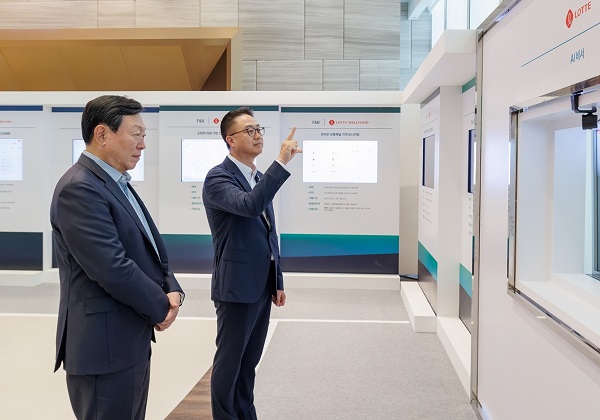 ▲ 롯데는 15일 롯데월드타워에서 '2026 하반기 VCM'을 개최했다. 본 회의에 앞서 그룹 AX 추진 현황 및 사례를 소개하는 'AI 에이전트 전시'를 진행했다. 신동빈 롯데 회장(왼쪽)이 황민재 롯데지주 경영혁신실장(오른쪽)으로부터 음성과 모션 인식 기반 'AI 비서'에 대한 설명을 듣고 있다. ⓒ롯데