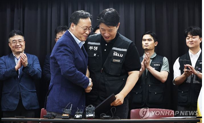 ▲ 지난 5월 경기도 수원시 장안구 경기고용노동청에서 열린 삼성전자 임금협상을 마친 후 여명구 삼성전자 DS(디바이스솔루션·반도체 사업 담당) 피플팀장과 최승호 삼성그룹 초기업노동조합 삼성전자지부 위원장이 잠정 합의안에 서명한 후 손을 맞잡고 있다.ⓒ연합뉴스