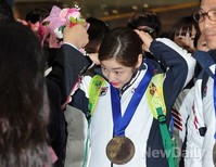 [포토]소치 올림픽 선수단 귀국, 머리정리하는 연아 '꽃목걸이는 머리좀 정리하구요!'