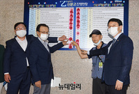 [포토] 더불어민주당, 아파트경비노동자 함께 '상생 꽃 달기'