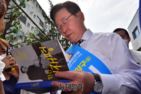 [포토] 지지자 책에 사인하는 이재명 후보