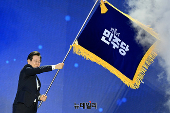[포토] 민주당기 흔드는 이재명 신임 대표
