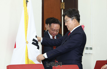 [포토] 국민의힘 당기 세우는 권성동 권한대행 