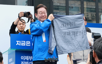 [포토] 창원서 작업복 들어 보이는 이재명 후보