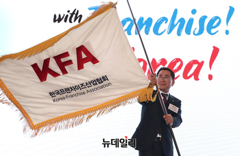 [포토] 협회기 흔드는 나명석 신임 한국프랜차이즈산업협회장